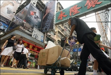 People cross a street at a busy shopping district in the Kowloon area of Hong Kong, October 2006. China cannot rule out further interest rate hikes in the coming months, state press have reported, citing a leading central bank advisor.(AFP