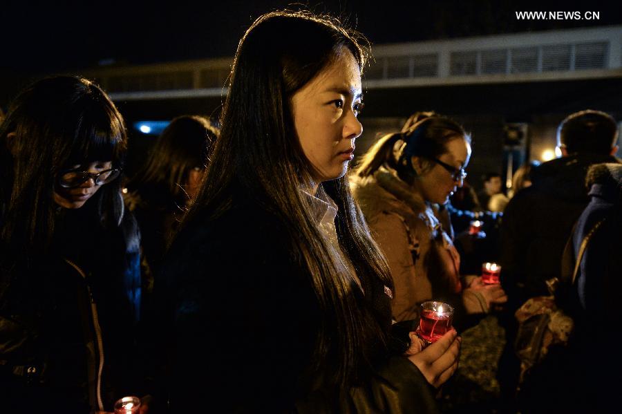 People hold candles to mourn victims of Nanjing Massacre