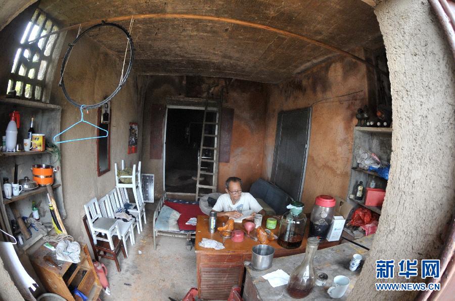 Elder digs cave house on hill in C China