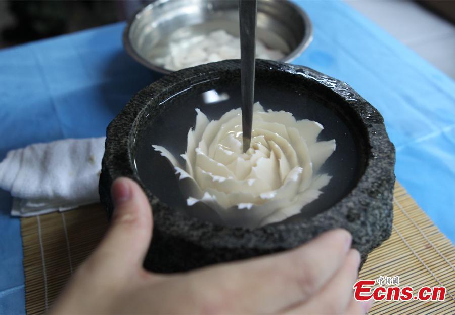 Man writes Chinese calligraphy using kitchenware