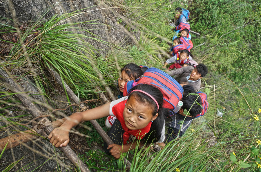 Kids climb vine ladder in 'cliff village' in Sichuan