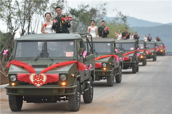 Couples exchange 'bullet shell rings' at group wedding in military camp