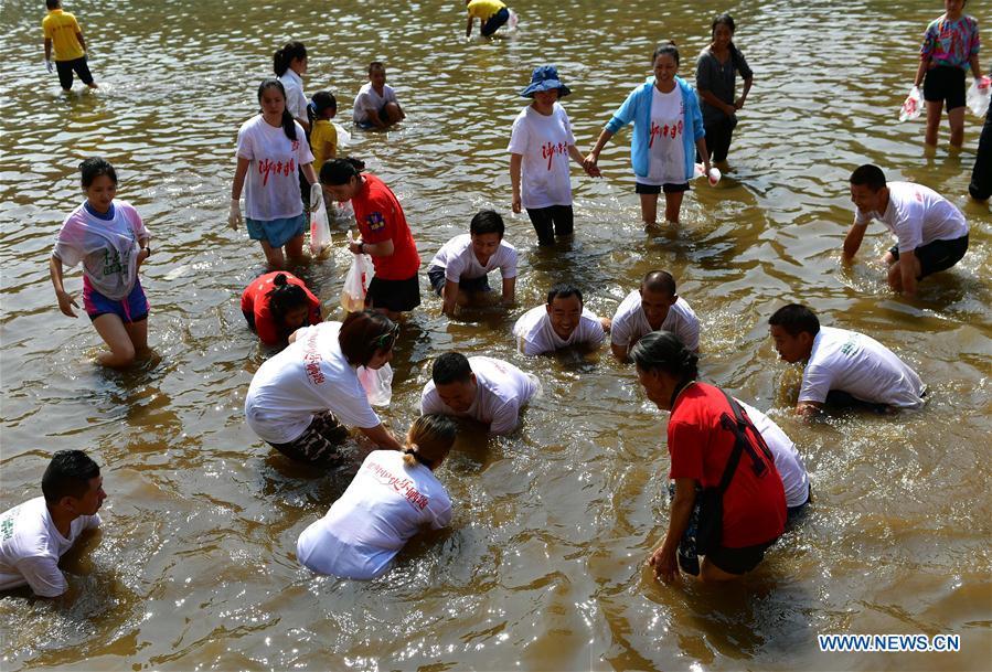 People catch fish in river to celebrate good harvest