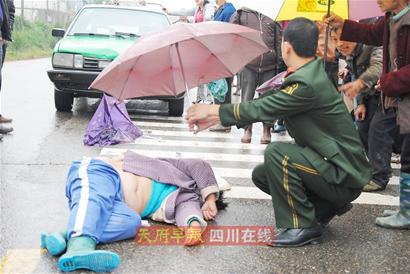 雨中撑伞遮雨守护车祸伤者 河南撑伞哥感动四川