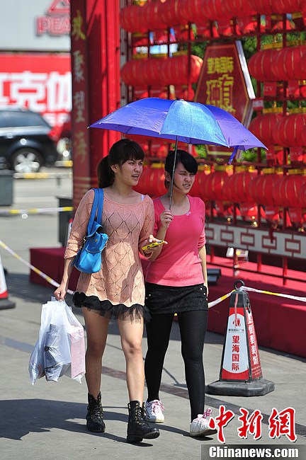 海南气温升至30℃ 民众着夏装出行