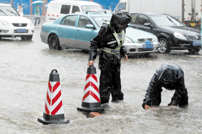 交警冒雨设警示柱坚守水中疏导交通
