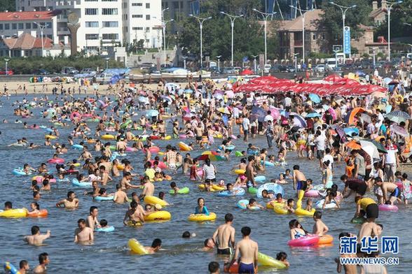 多地遭遇高温天——青岛海滨浴场成“人海”