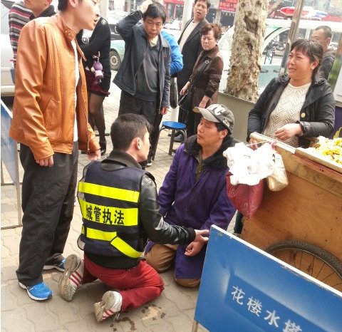 武汉摊贩因车辆被扣下跪求情 城管与其“对跪”