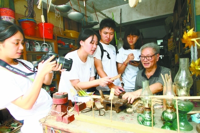 大学生向手工师傅请教传统工艺