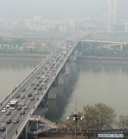 Vehicles run amid fog on Wuyi avenue in Changsha, capital of central China's Hunan Province