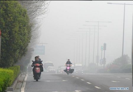 Vehicles run amid fog on Wuyi avenue in Changsha, capital of central China's Hunan Province