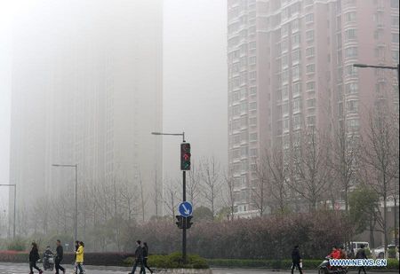 Vehicles run amid fog on Wuyi avenue in Changsha, capital of central China's Hunan Province