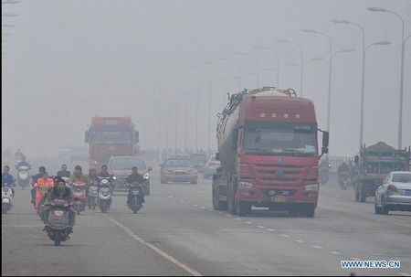 Vehicles run amid fog on Wuyi avenue in Changsha, capital of central China's Hunan Province