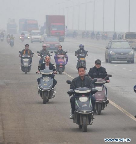 Vehicles run amid fog on Wuyi avenue in Changsha, capital of central China's Hunan Province