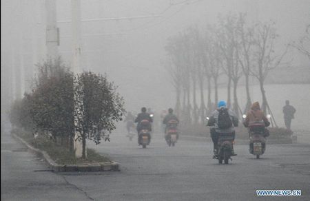 Vehicles run amid fog on Wuyi avenue in Changsha, capital of central China's Hunan Province