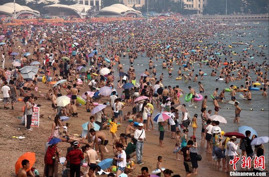 多地遭遇高温天——青岛海滨浴场成“人海”