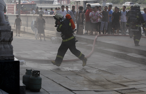 北京朝阳一餐厅二层楼顶着火 消防队员紧急扑救
