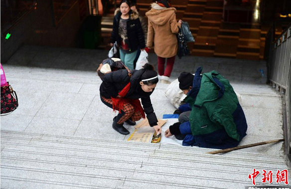 八旬乞丐捡银行卡后举牌寻失主 市民纷纷伸援手