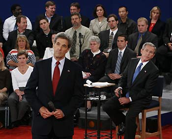 Democratic presidential nominee John Kerry (L) and U.S. President George W. Bush listen to a question from the audience during the town hall format debate at Washington University in St. Louis Missouri, October 8, 2004. The latest polls have the two candidates in a statistical dead heat with about three weeks until the election and one final debate in Arizona next week.