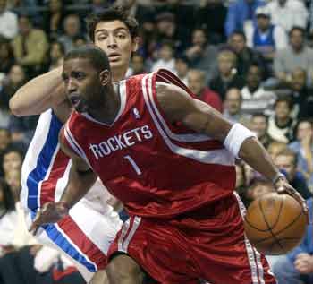 Houston Rockets guard Tracy McGrady (1) drives around Detroit Pistons guard Carlos Delfino in the first half of the Pistons season home opener at the Palace in Auburn Hills, Michigan, November 2, 2004. [Reuters]
