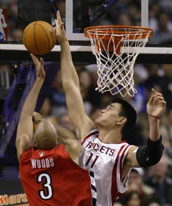 Houston Rockets center Yao Ming (R) blocks a shot by Toronto Raptors center Loren Woods during the first half of their NBA game in Toronto November 3, 2004. [Reuters]