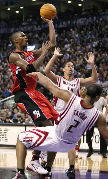 Toronto Raptors forward Chris Bosh (L) shoots after running into Houston Rockets forward Maurice Taylor during the second half of their NBA game in Toronto, November 3, 2004. Bosh was called for a foul on the play and received a technical foul for arguing the call. Bosh led the Raptors in scoring with 20 points as the Raptors defeated the Houston Rockets 95-88. [Reuters]