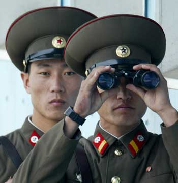 North Korean soldiers stand guard at the truce village of Panmunjom in the demilitarized zone separating the two Koreas, about 55 km (31 miles) north of Seoul, November 9, 2004. [Reuters]