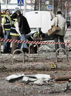 Investigators gather evidence following a car bomb explosion near Madrid's main convention center, February 9, 2005. The blast came after a warning from the Basque separatist group ETA and injured 39 people.