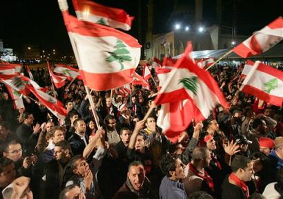 Lebanese opposition supporters protest whilst waving Lebanese flags as they shout anti-Syrian slogans during a demonstration against Syria and the Lebanese government at the Martyrs square in down town Beirut, Lebanon, Sunday Feb. 27, 2005. Shortly afterward, the Lebanese Army Command issued a statement calling on citizens not to demonstrate or gather in all Beirut areas, especially in squares and streets surrounding the Parliament building starting from 5 a.m. (0300 GMT) on Monday. [AP]