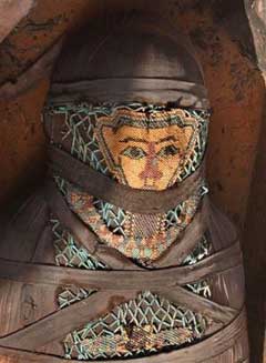 The face of a decorated mummy inside an ancient wooden coffin, shaped like human body that date back to the 26th Pharaoh Dynasty that ruled from 672 BC to 525 BC, is seen in Sakkara, south of Cairo Wednesday, March 2, 2005. Australian archaeologists have discovered one of the best preserved ancient Egyptian mummies dating from about 2,600 years ago, Zahi Hawass, the head of Egypt's Supreme Council for Antiquities said. (AP 