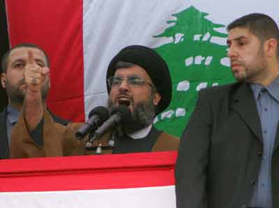 Hizbollah chief Sheikh Hassan Nasrallah (C) is surrounded by bodyguards as he addresses the crowd in central Beirut March 8, 2005. Hundreds of thousands of flag-waving Lebanese flooded central Beirut on Tuesday for a pro-Syrian rally called by Hizbollah that dwarfed previous protests demanding that Syrian troops quit Lebanon. [Reuters]