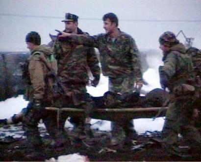 A TV grab shows Russian Interior Ministry soldiers carrying a victim of a military helicopter crash, south from Chechen capital of Grozny, March 10, 2005. The Mi-8 transport helicopter crashed possibly as a result of flying into power lines. At least 11 soldiers were killed and two have been taken to hospital, local Interior Ministry spokesman Ruslan Atsayev said. CIS OUT REUTERS/NTV Television Channel 