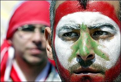 National colors : A Lebanese man, his face painted in the national colors, waits for the start of an anti-Syrian mass rally in downtown Beirut. 