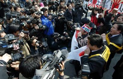 South Korean protesters are surrounded by media during a rally against Japan's sovereignty claims over South Korea's Dokdo islets in front of the Japanese Embassy in Seoul Wednesday, March 16, 2005. South Korea on Wednesday vowed to maintain its grip on islets also claimed by Japan after a provincial Japanese assembly asserted Tokyo's claims in a vote that the Seoul government called deplorable but without impact. [AP]