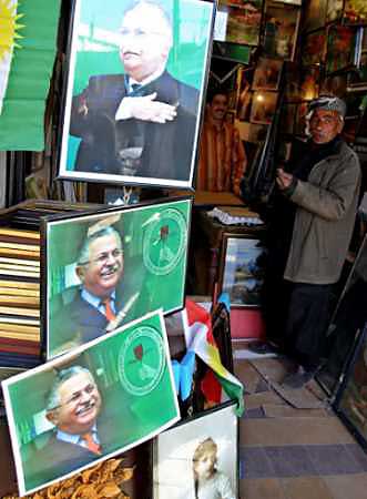 An Iraqi Kurdish man shops near posters of Kurdish leader and presidential candidate Jalal Talabani in the northern city of Suleimaniya, March 15, 2005. [Reuters] 