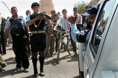 An Iraqi Police officer points his rifle at another in jest during a demonstration against the U.S. military presence and the detainment of Iraqis in Samarra, Iraq Tuesday, April 12, 2005. Emboldened by a newly elected government and the growing ranks of homegrown security forces, Iraqis are increasingly calling on American forces to leave their troubled nation, even though Iraqi leaders say it is too early for a U.S. pullout. (AP Photo/Hameed Rasheed) 