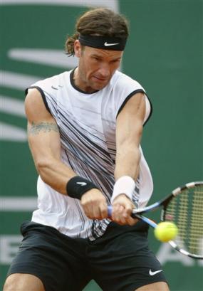 Spanish player Carlos Moya returns the ball to Max Mirnyi of Belarus during their third round match of the Godo Tennis tournament in Barcelona, Spain, Thursday, April 21, 2005 which Mirnyi won 6-4, 6-3. (AP