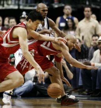 Dallas Mavericks guard Jerry Stackhouse (C) scrambles with Houston Rockets center Yao Ming (L) and guard David Wesley for a loose ball during second half action in Game 5 of the 2005 NBA Western Conference quarterfinals, in Dallas, Texas May 2, 2005. Dallas defeated Houston 103-100 to lead the best-of-seven series 3-2. REUTERS