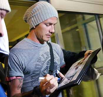 Real Madrid's David Beckham of Great Britain signs autographs after arriving from London at JFK International Airport in New York May 29, 2005. Beckham and fellow Briton Michael Owen arrived Sunday to join England's squad that will play Colombia on May 31. [Reuters]