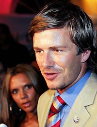 England soccer captain David Beckham (R) and his wife Victoria arrive at a party after London won the 2012 Olympics bid in Singapore July 6, 2005.