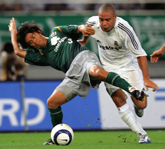 Real Madrid's forward Ronaldo of Brazil (R) fights for the ball with Tokyo Verdy's defender Kenta Togawa during the first half of their international friendly match at Ajinomoto Stadium in Tokyo July 25, 2005.