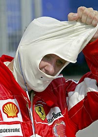 Ferrari Formula One driver Michael Schumacher of Germany takes off his hood after he finished second at the Hungarian Grand Prix on Hungaroring near Budapest, July 31, 2005. 