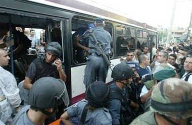 Israeli security forces inspect a bus, after an Israeli soldier opened fire inside the bus killing four, in the northern Israeli town of Shfaram, Thursday, Aug. 4, 2005.