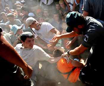 Israeli border police clash with Jewish settlers as they block an Israeli army truck at the Jewish settlement of Kfar Darom in the Gush Katif bloc in Gaza Strip August 7, 2005. Israeli Finance Minister Benjamin Netanyahu resigned in protest on Sunday as the cabinet approved the first phase of evacuations from settlements in the occupied Gaza Strip.