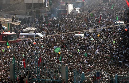 Ambulances remain on standby among the crowd of Iraqi pilgrims near the Kadhimiya mosque in Baghdad August 31, 2005. More than 600 Iraqi Shi'ites died in a stampede over a Tigris River bridge in Baghdad on Wednesday, panicked by rumours a suicide bomber was about to blow himself up, an Interior Ministry source told Reuters. A large crowd had been heading towards the mosque for a religious ceremony when someone yelled there was a suicide bomber among them. 