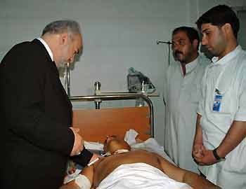 Iraqi Prime Minister Ibrahim al-Jaafari speaks to a man, who was injured during a stampede, at the Al-Kadhimiya hospital in Baghdad September 1, 2005. Crowds gathered on Thursday for the funerals of some 1,000 Iraqis killed in a stampede during a religious festival, as the nation grieved over a tragedy which has overshadowed the daily bloodshed of war. REUTERS