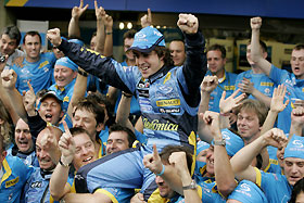 Renault's Formula One driver Fernando Alonso (C) of Spain celebrates with his team's mechanics after finishing third in the Brazil Grand Prix in Sao Paulo September 25, 2005.