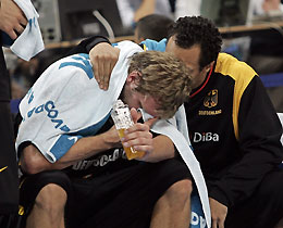 Germany's Dirk Nowitzki (L) is comforted by his teammate Demond Greene at the end of the match against Greece at European basketball championships final match in Belgrade September 25, 2005.
