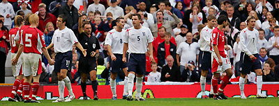 England's captain David Beckham (R) is shown the red card by Spanish referee Luis Medina Cantalejo (4th L in black) during their World Cup 2006, Group Six qualifying soccer match against Austria at Old Trafford in Manchester, northern England, October 8, 2005. 