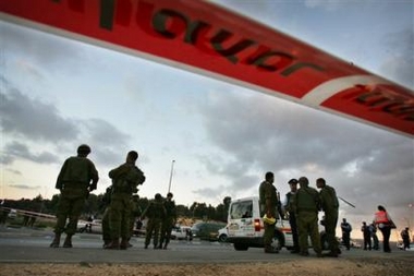 Israeli soldiers and paramedics stand at the scene of a shooting attack at the Gush Etzion Junction south of Jerusalem Sunday Oct. 16, 2005.